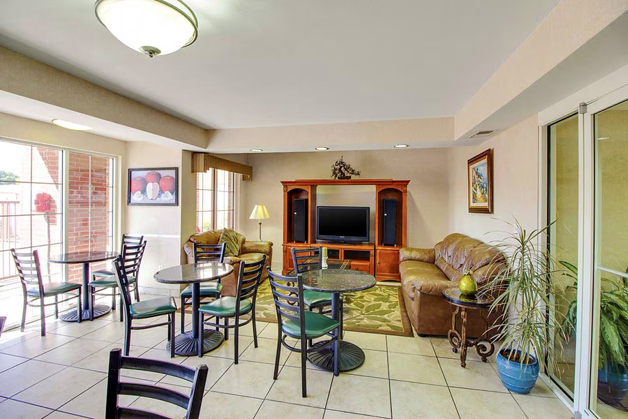Lounge and dining area with tables, chairs and doors to the courtyard.