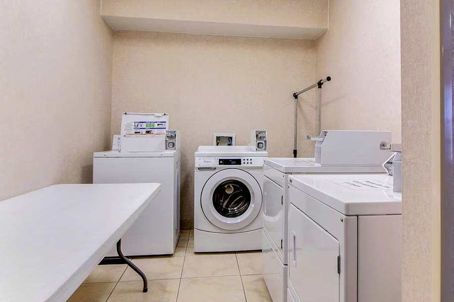 Guest laundry room with washers, dryers and a folding table.