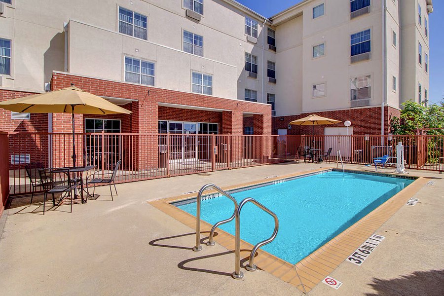 Outdoor pool with loungers and shade umbrellas in the hotel courtyard.